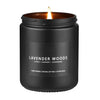 A black jar candle with a lit wick, labeled Lavender Woods, for relaxation.