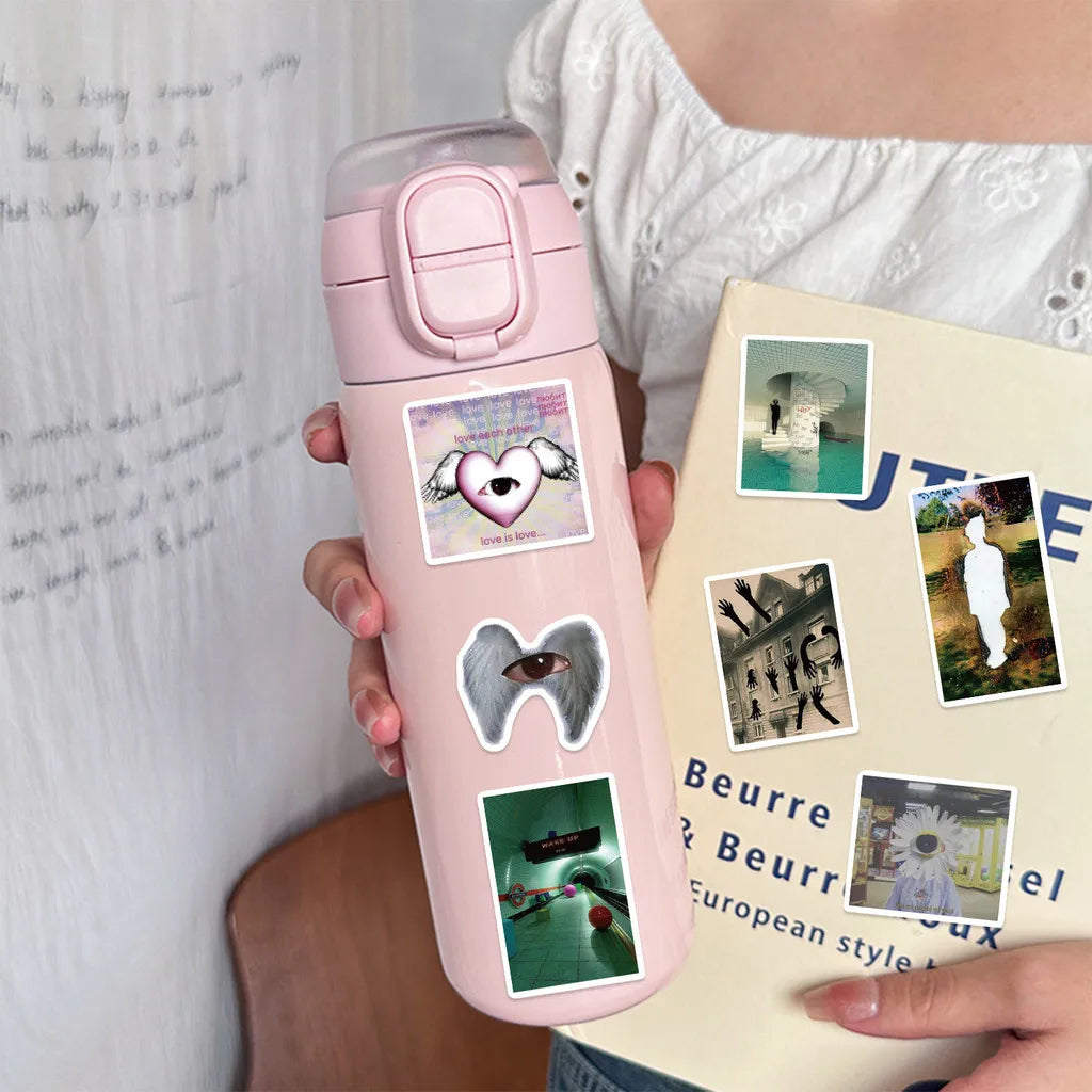 A pink cosmetic bottle with heart and animal stickers is held against a white background.