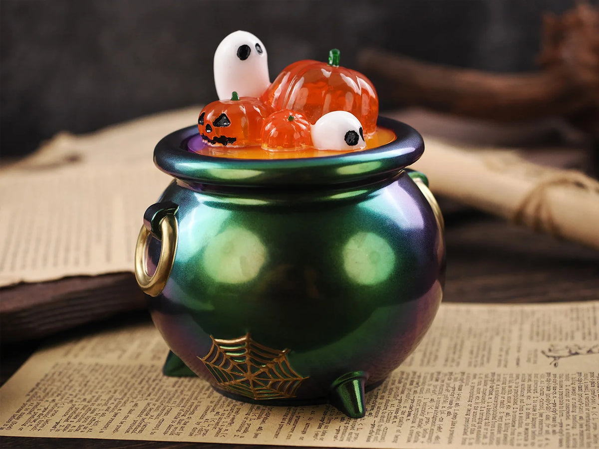 A green ceramic pot holds a Halloween silicone mold set featuring orange pumpkins and white ghosts.
