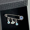 An elegant gold and silver evil eye brooch pin featuring multiple blue and silver eye charms.