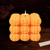 A yellow silicone mold shaped like a smiling pumpkin used for making candles and resin crafts.