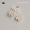 A single white soy wax flower tea light candle in clear packaging with a pink flower label.