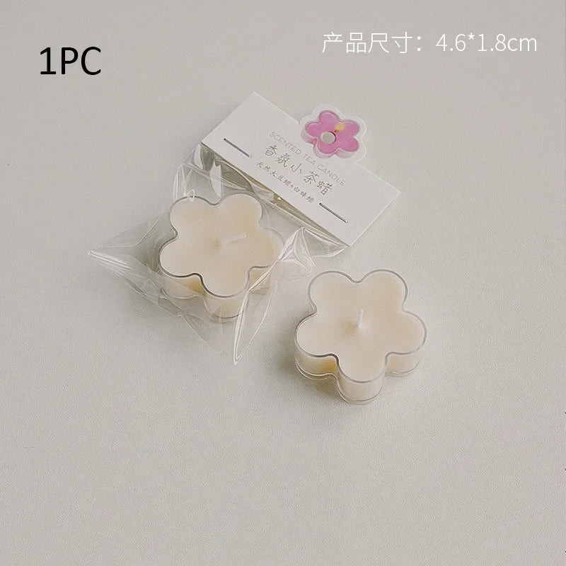 A single white soy wax flower tea light candle in clear packaging with a pink flower label.