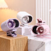 A pink and white adjustable clip-on mini electric fan is displayed on a wooden block and marble surface.