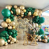 A balloon arch display featuring metallic gold and dark green balloons with floral accents.