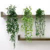 A set of four artificial eucalyptus hanging vines displayed on a wooden shelf.