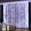 LED curtain string lights hanging in a window with a remote control visible nearby