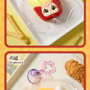 A yellow and red French fries shaped collectible squeeze toy keychain is displayed on a white plate.