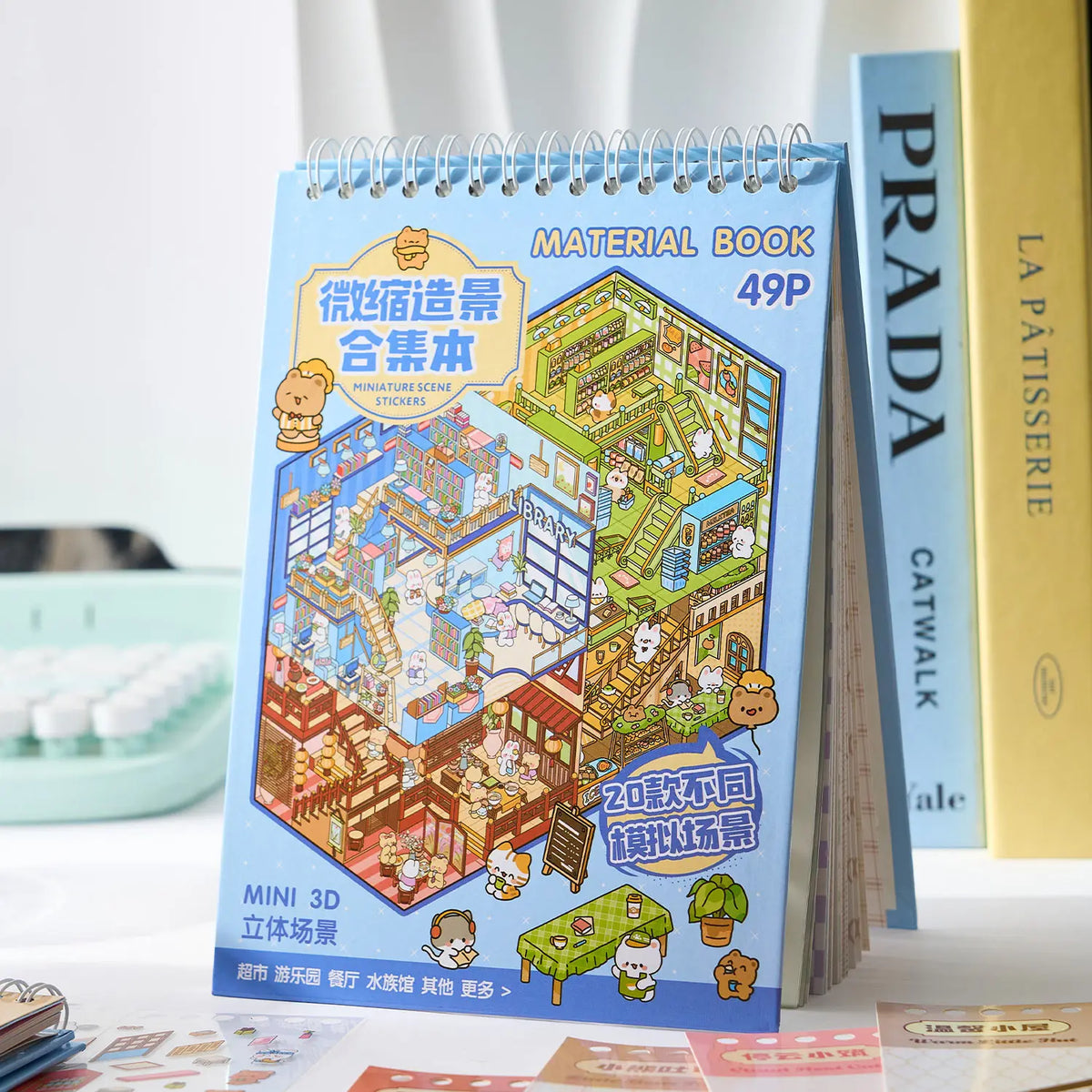 A blue spiral-bound book titled Material Book featuring a Kawaii Miniature Scene Sticker Book for kids