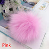 Pompon en fourrure synthétique rose et rose à l'enfilage, présenté sur fond blanc.