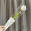 A clear plastic sleeve holds a handmade crochet white tulip flower with a green stem, labeled LOVE.