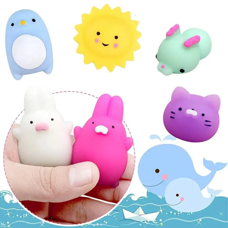 A collection of mini cartoon animal stress relief toys including a blue penguin, yellow sun, green frog, white rabbit, and pu
