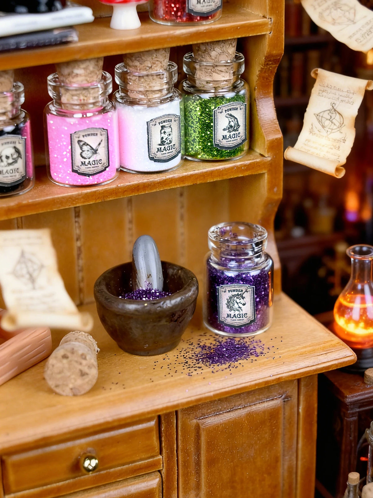 A collection of colorful glitter powders and jars displayed on a wooden shelf with parchment labels.