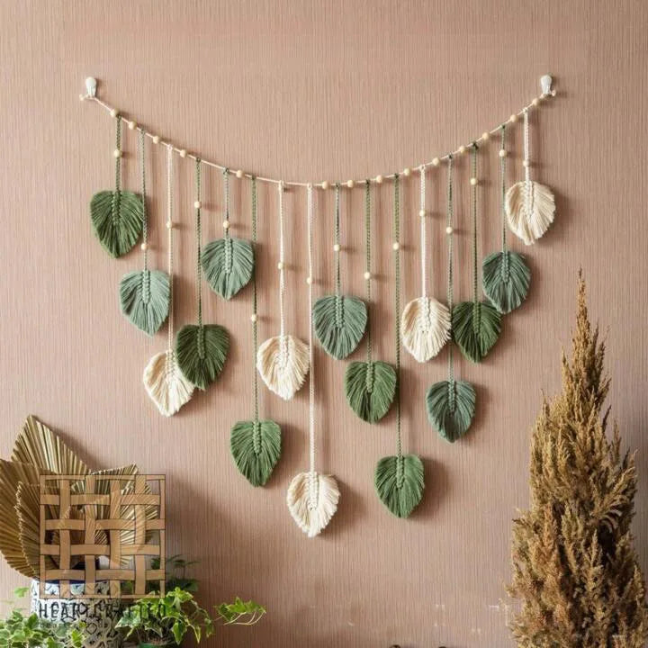 Bohemian macrame leaf wall hanging featuring various sized green and cream leaves with tassels