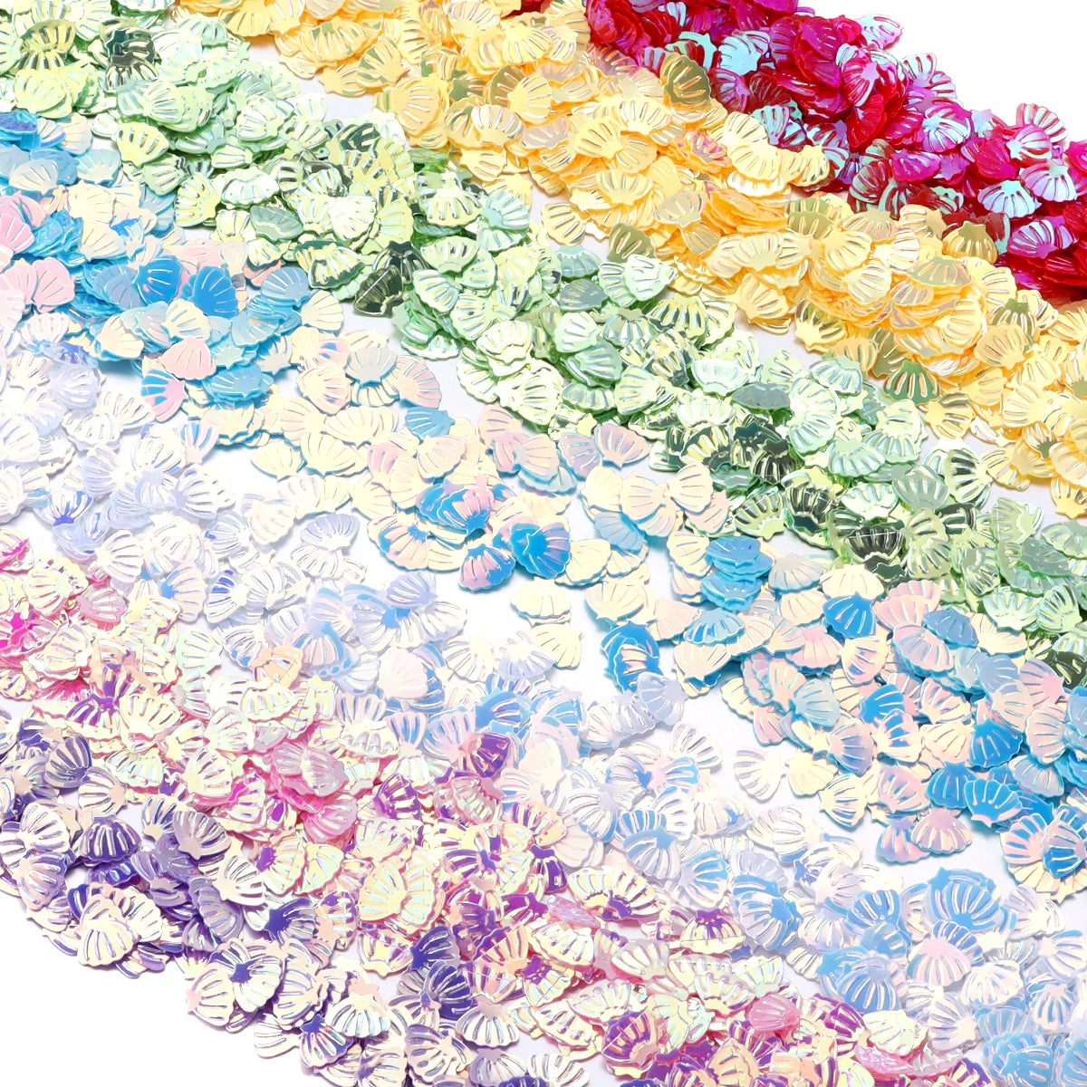 A close-up of iridescent sea shell PVC sequins in various shades of pink, yellow, green, and blue.