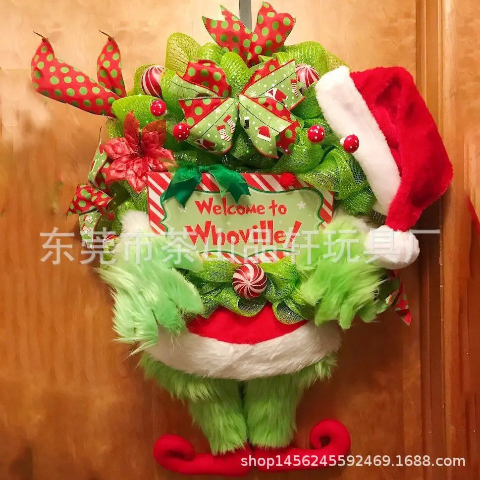 Green monster Christmas wall decor featuring festive red and green ribbon accents