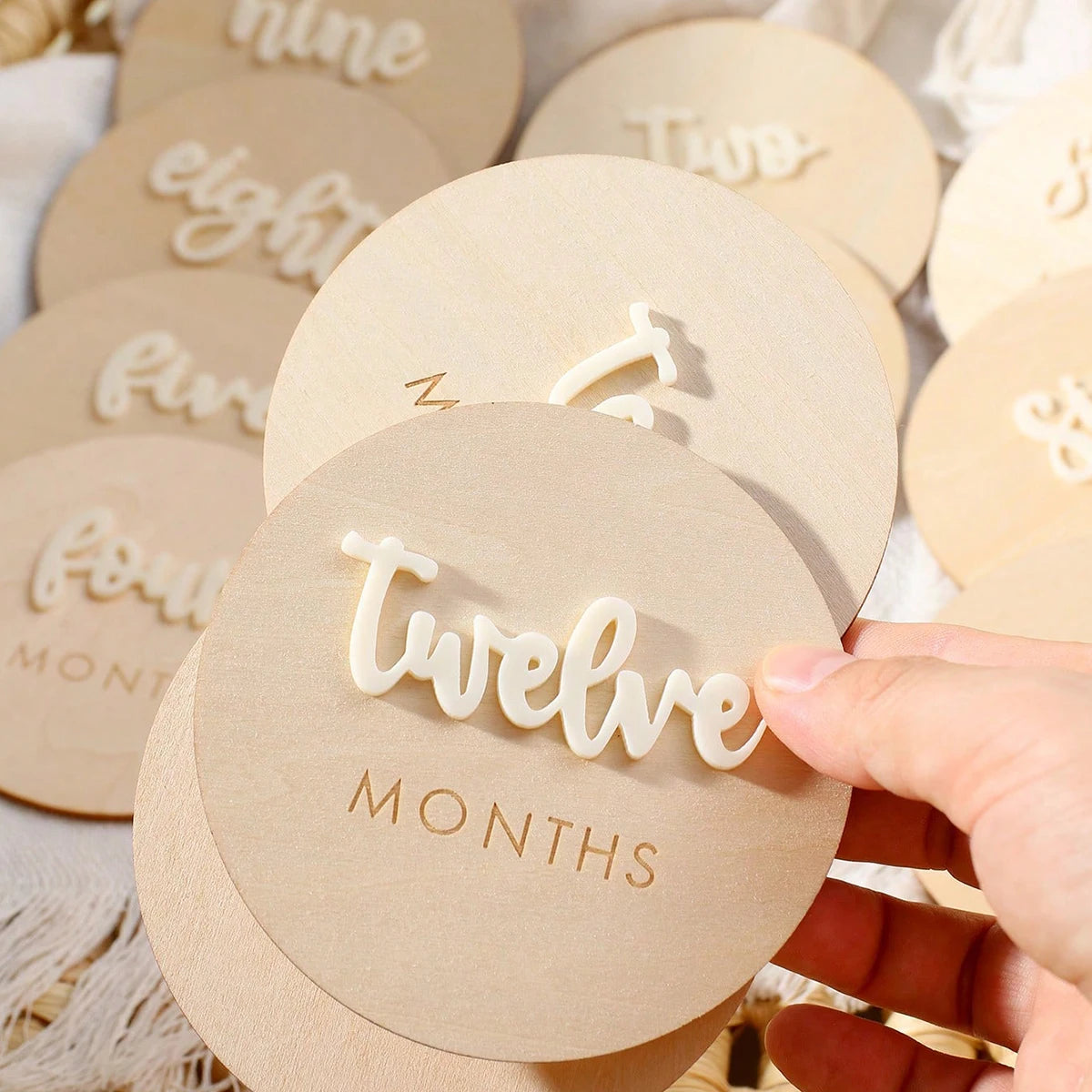 A set of wooden baby milestone cards showing numbers from one to twelve for newborn keepsakes