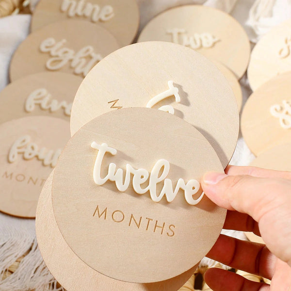 A set of wooden baby milestone cards showing numbers from one to twelve for newborn keepsakes