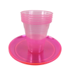 Une pile de gobelets en plastique jetables roses à l'éclairage néon avec un couvercle assorti rose.