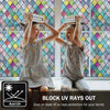 Two children look through a rainbow stained glass window film indoors