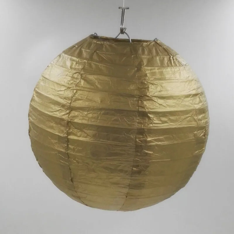 A large, round, golden paper lantern suspended by a wire hanger.