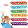 A child holds a colorful set of unicorn themed party supplies featuring various stickers and decorations.