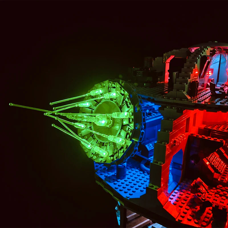 A close-up view of a Death Star LED lighting kit illuminating a section of a building set with green and red lights.