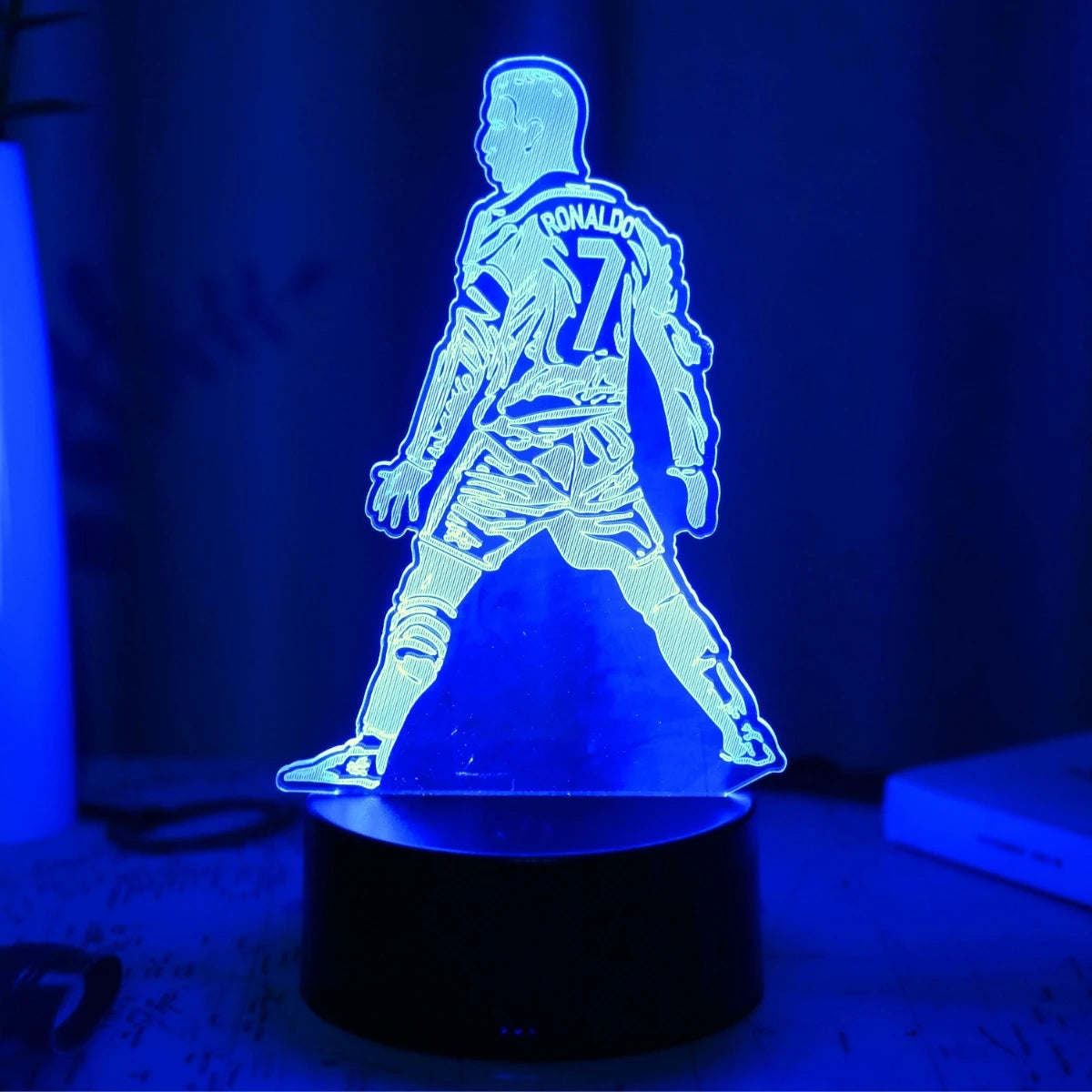 A glowing blue silhouette of a football player wearing number 7 stands on a black base.