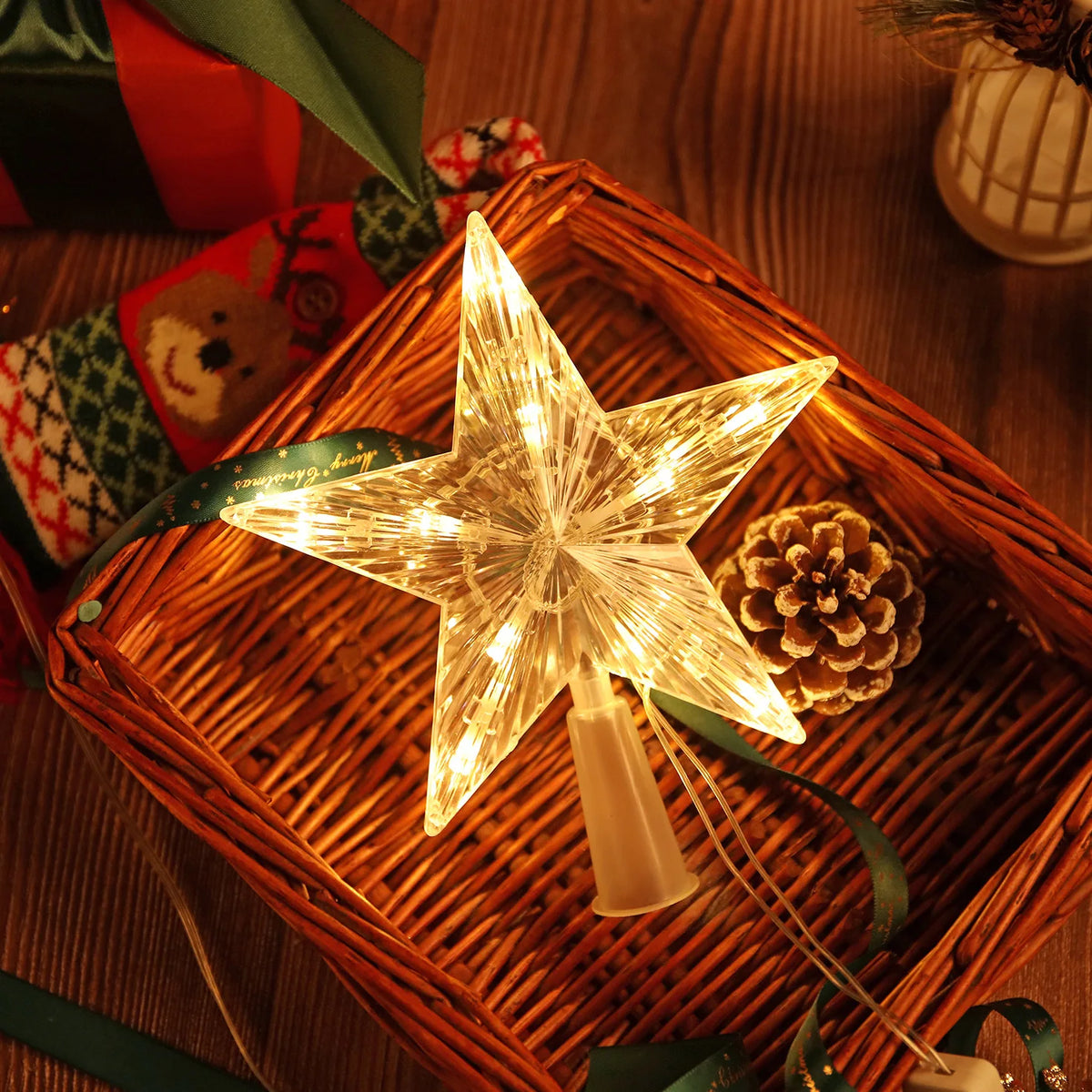 A glowing, star-shaped LED Christmas tree topper rests in a woven basket on a wooden surface.