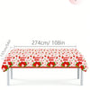 A long red table covered with a strawberry pattern, featuring disposable tableware for a birthday party.