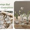 A collection of small vintage bud glass vases for centerpieces arranged on a wooden surface.