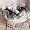 A round table covered with a marble print tablecloth featuring black, white, and gold veining.