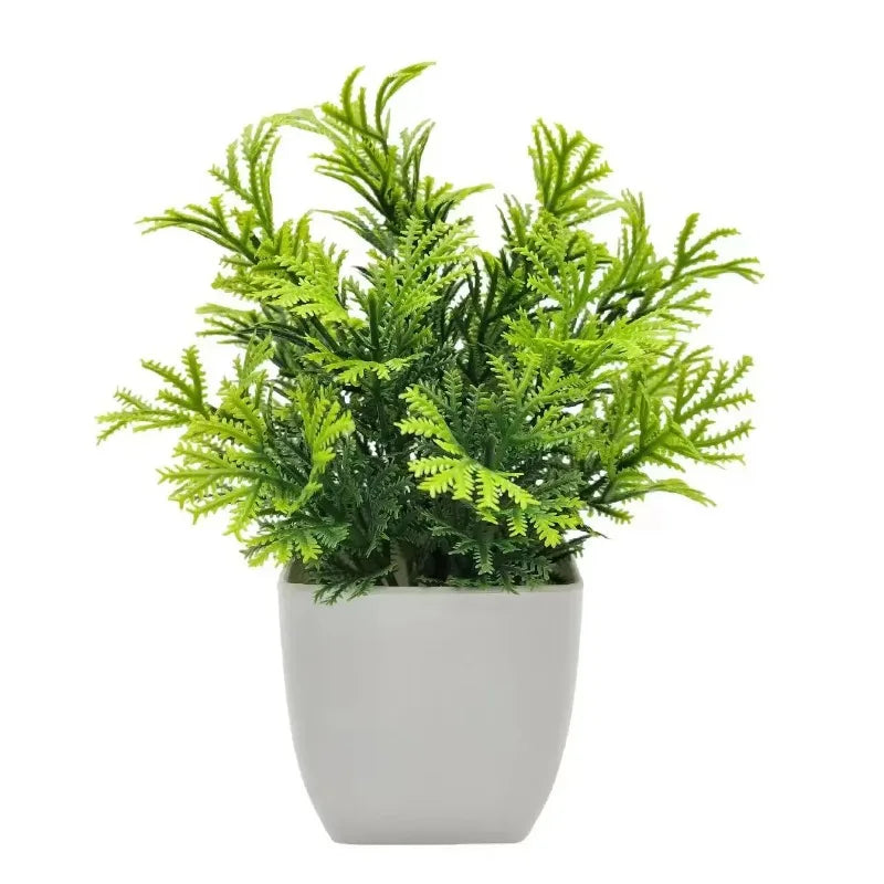 Lebendiges grünes Kunstbonsai-Pflanze in einem weißen Topf.