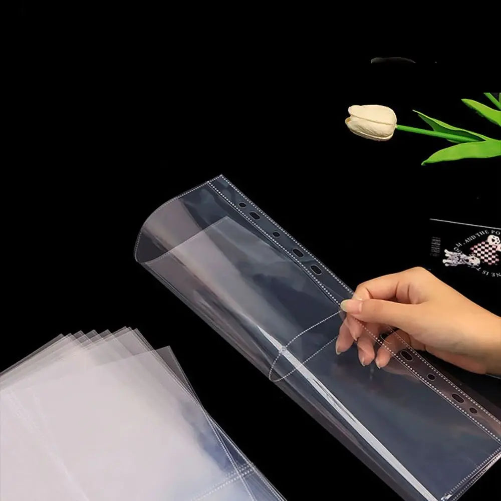 Una mano sostiene una hoja de carpeta plástica transparente con costura decorativa y una flor blanca, demostrando el producto