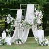 Elegant chiffon arch drapes in white and green floral arrangements for a wedding backdrop.