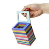 A hand holds a light green magnetic photo frame with a stack of colorful frames below it.