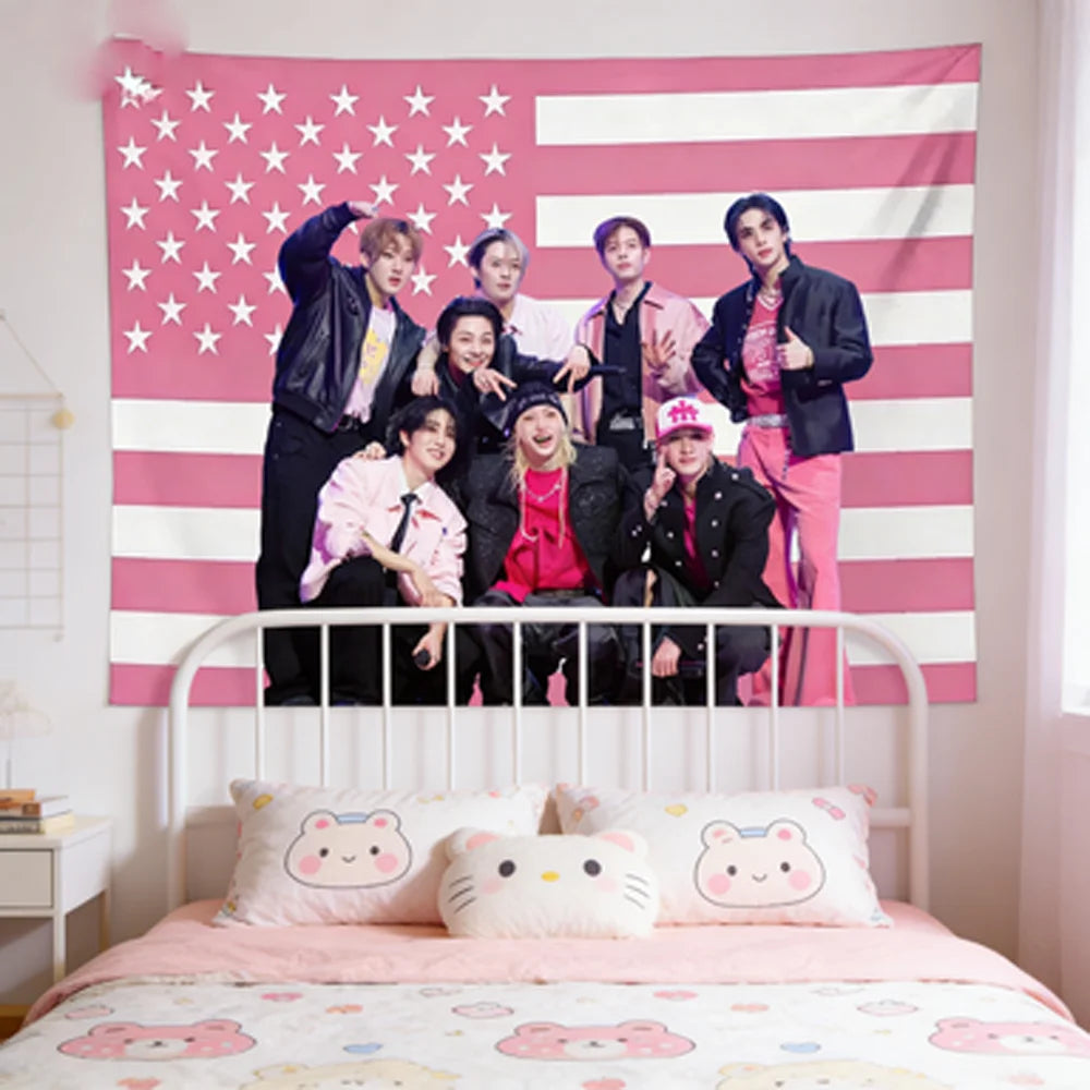 A pink American flag tapestry featuring stars and stripes hanging above a white bed with pink bedding.