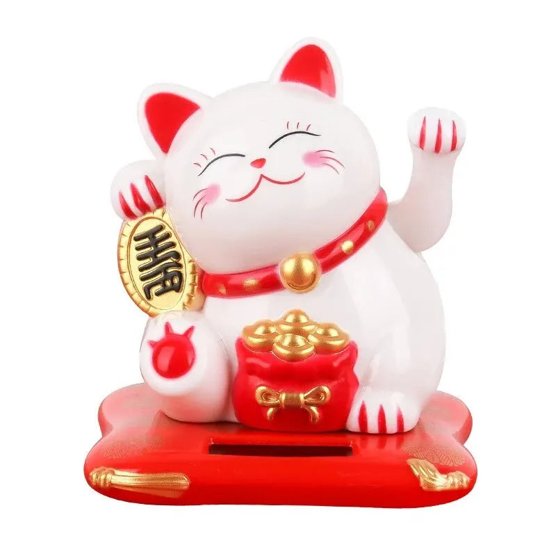 A white ceramic cat figurine with closed eyes and a red collar sitting on a red base.