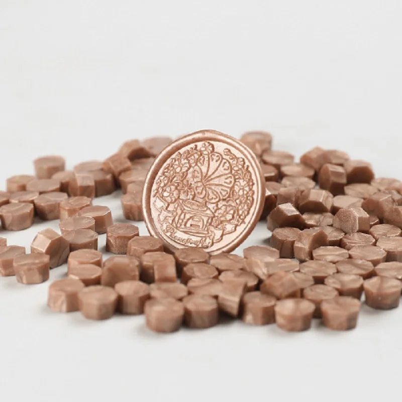 A pile of round, light brown wax sealing beads for custom stamps.