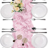 A rustic pink semi-sheer gauze table runner is displayed with a full place setting including plates, silverware, and a center