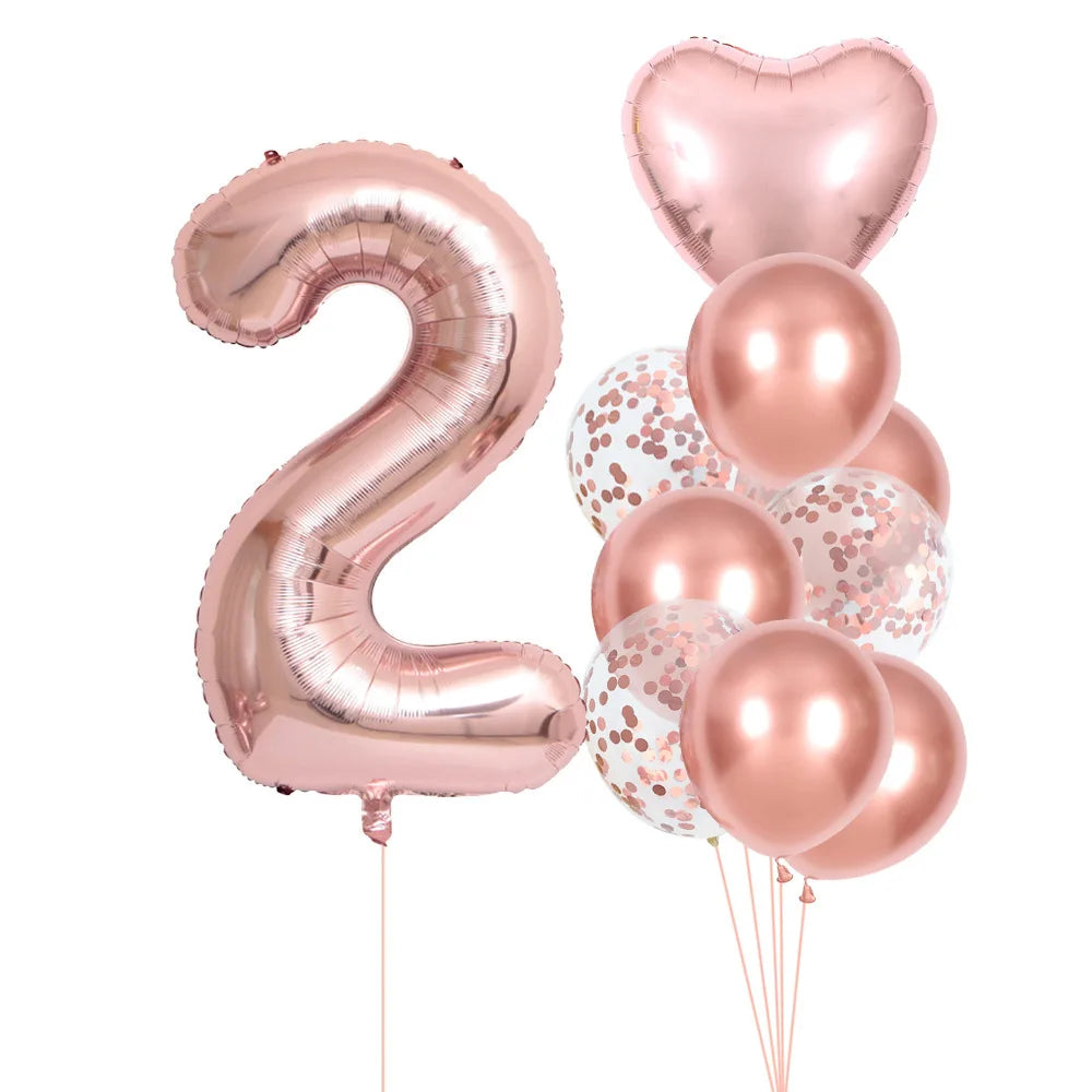 A set of rose gold foil balloons shaped like the number 2 and several round balloons for party decoration