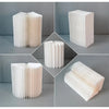 Supports à gâteau en papier plié blancs et élégants, montrés sous divers angles et empilés.