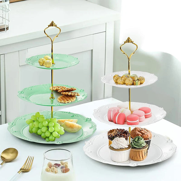 A three-tier plastic cupcake stand with green plates holding small pastries and cupcakes.