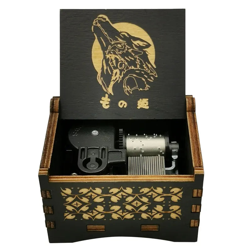 A wooden box containing a black metal music box with a gold-colored design and Japanese text.