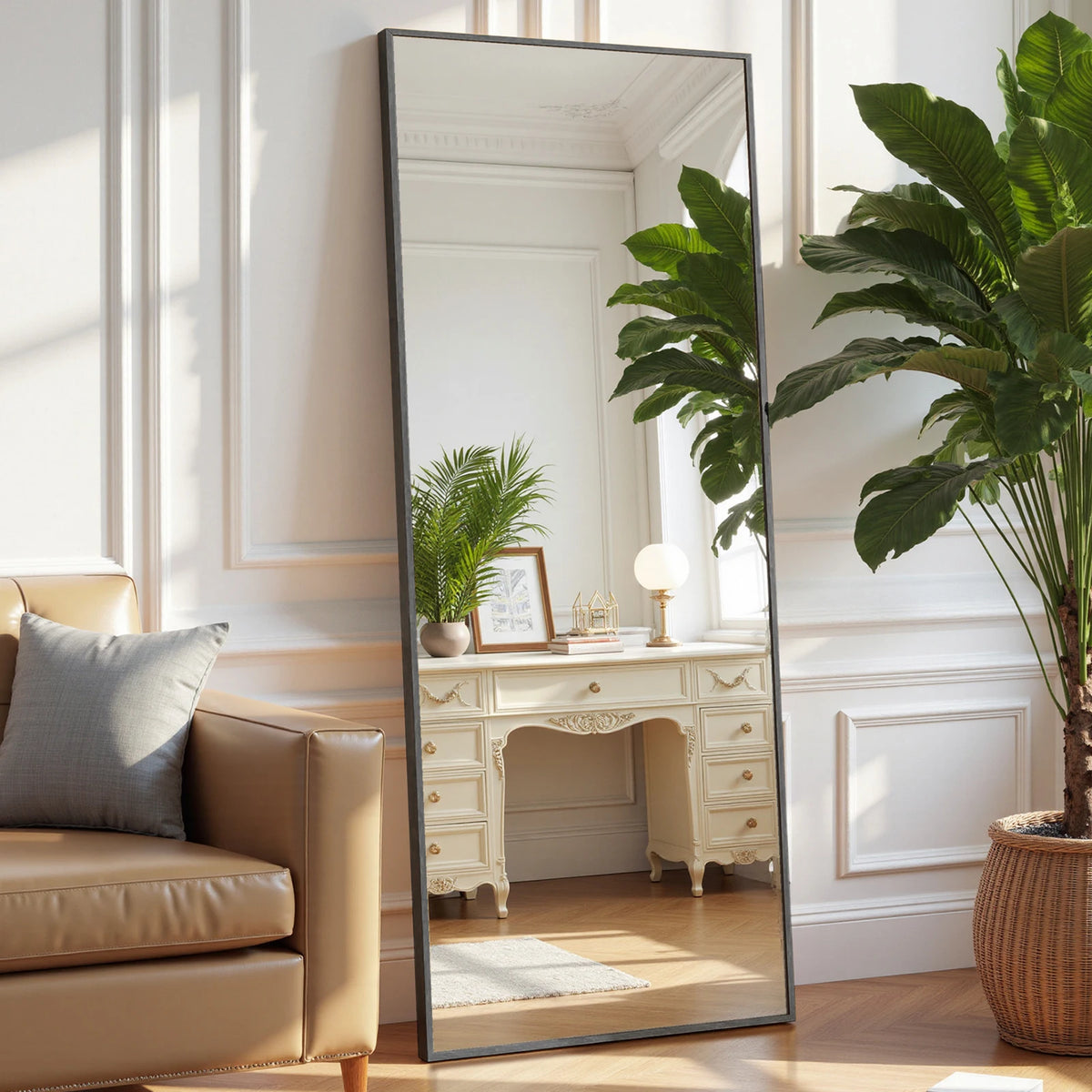 An arched full-length floor mirror with an aluminum frame reflecting a room interior and a large green plant.