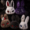 A collection of dark and light colored bunny plush keychains with various expressions and textures.