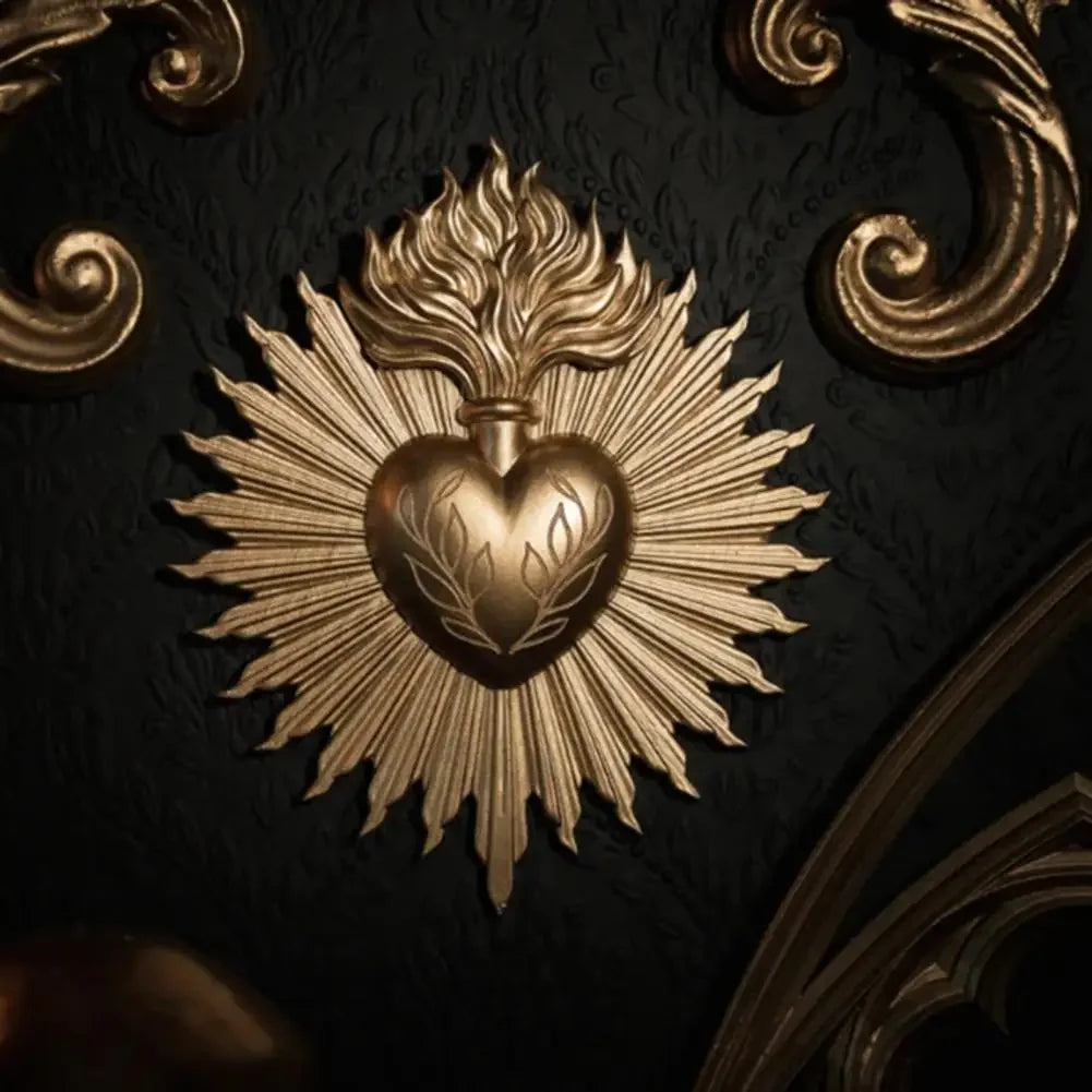 Gold relief plaque depicting a sacred heart surrounded by radiating rays on a dark background.