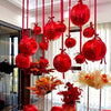 A collection of glossy red round foil balloons are suspended in a vertical display.