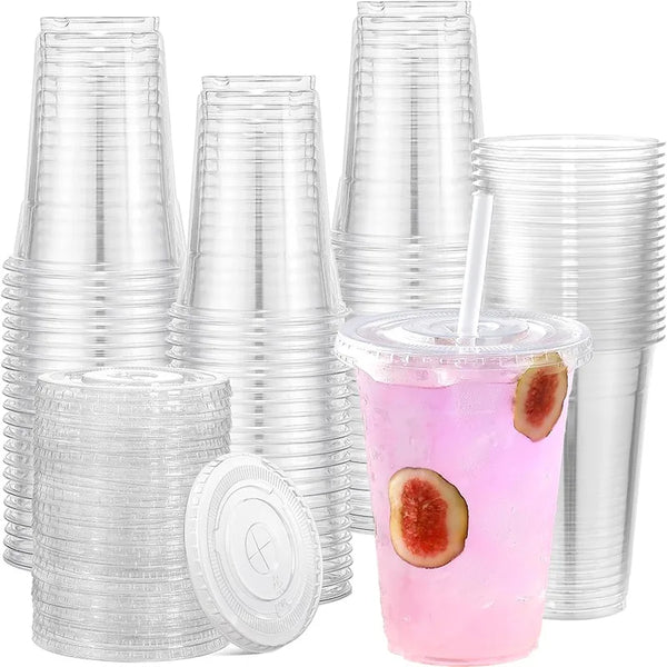 A stack of clear disposable plastic cups with flat lids and a glass containing pink beverage and fruit slices.