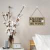 A vintage wooden farmhouse hanging sign with the text Help Wanted on a light gray wall.
